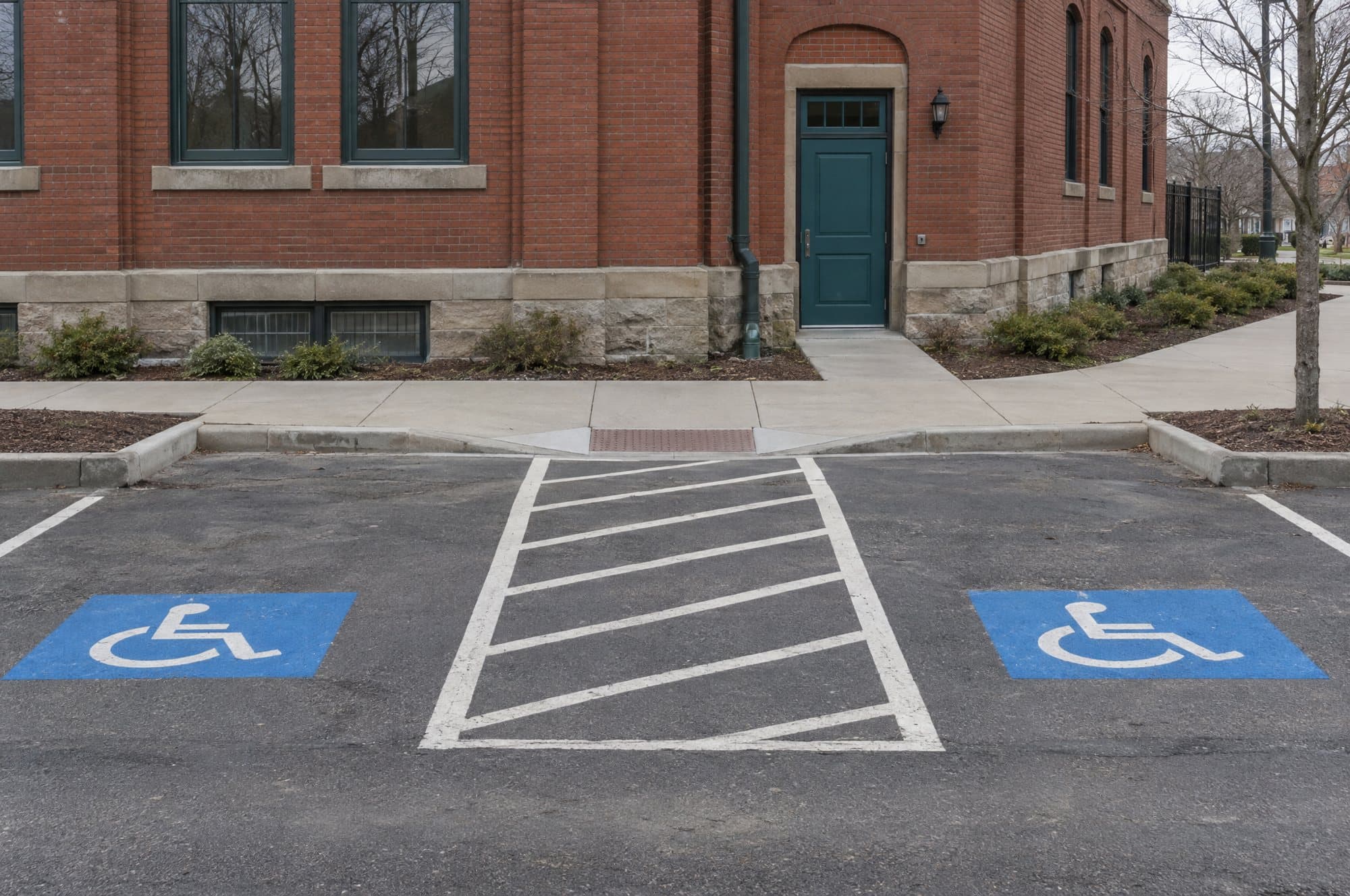 Two accessible parking spaces on Mill Street, with a curb cut leading to the museum's side door.