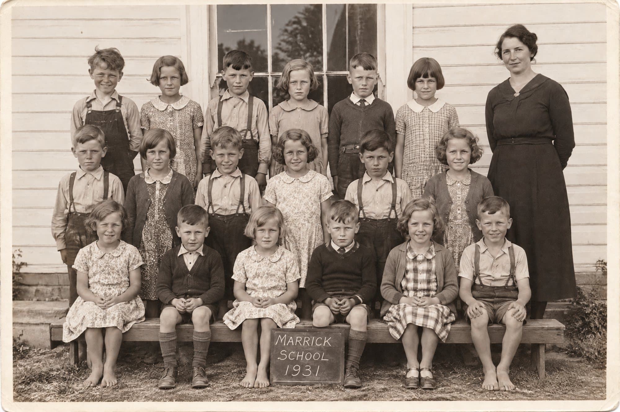 Marrick School, Grades 3 and 4, June 1931: eighteen children in three rows in front of the schoolhouse, with their teacher at the right.